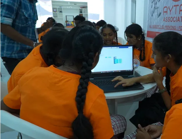 Students working together around a laptop