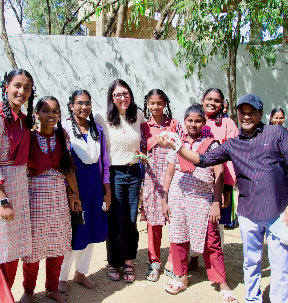 Students and adults standing together outdoors while holding project parts